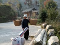 Femme Dong se préparant à faire sécher le maïs sur la route