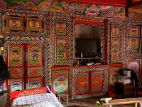 Habitation traditionnelle près de Danba : à côté de l'âtre, le lit. Les armoires tibétaines sont toutes peintes.